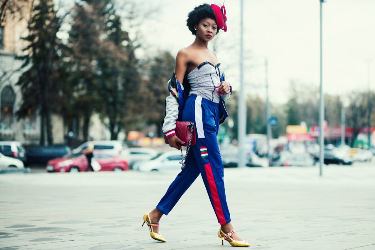 Stylish woman in vibrant outfit walking confidently in cityscape environment.